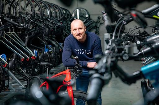 We zien Johan De Mulder in zijn zaak B2Bike in Stabroek met op de achtergrond een heleboel fietsen.